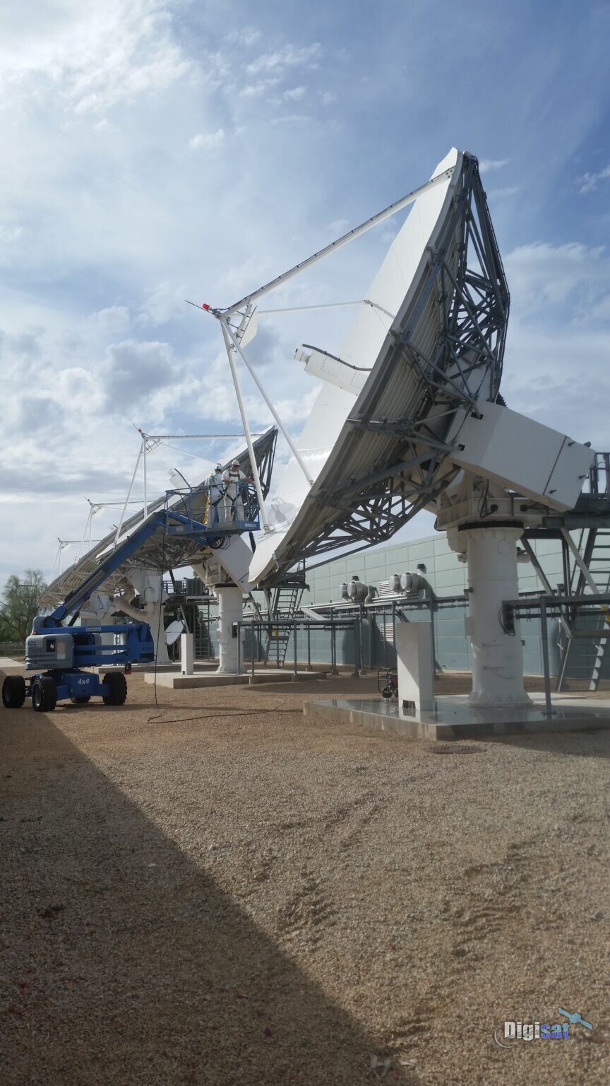 Large teleport earth station antennas with a crew working from a lift